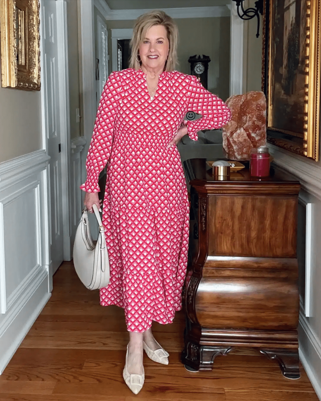 Tania Stephens in a navy long-sleeve V-neck smocked waist midi dress with pointed-toe bow slingbacks and a tan faux leather shoulder bag.
